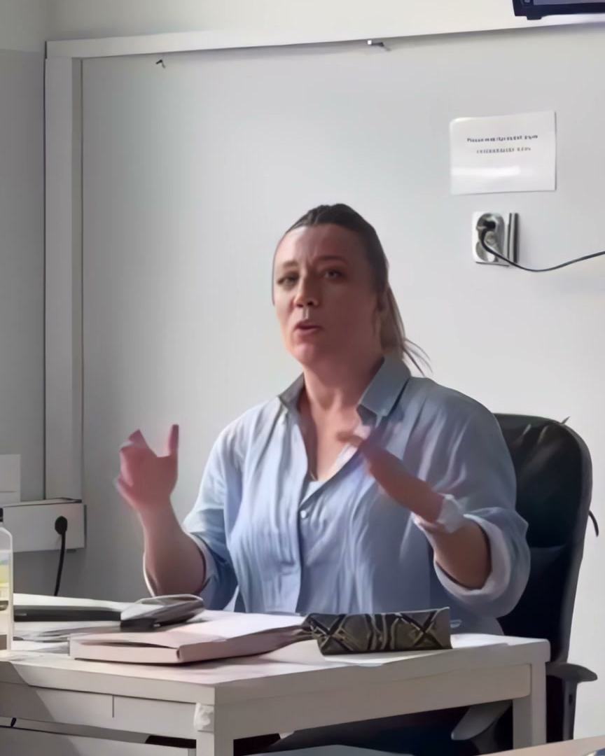 A teacher at IAS Warsaw at her desk, talking with her class