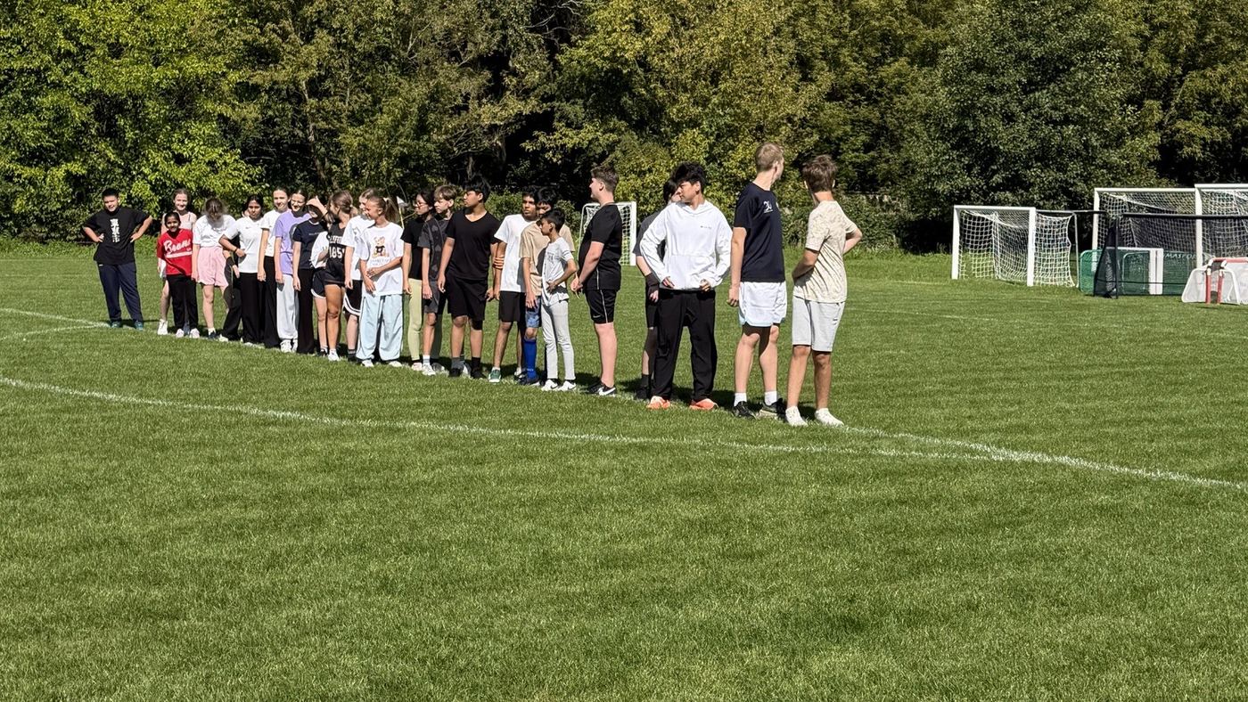 Uczniowie ustawieni w szeregu na szkolnym boisku w Konstancinie