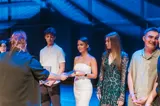 Students of the International American School of Warsaw receiving certificates on stage