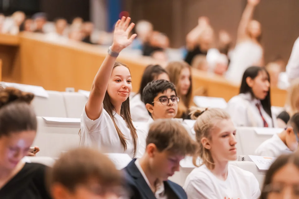 IAS students taking part in a school event, with a hand raised