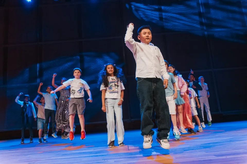 IAS students jumping together during a stage performance