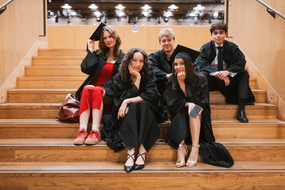 IAS graduates sitting together on steps